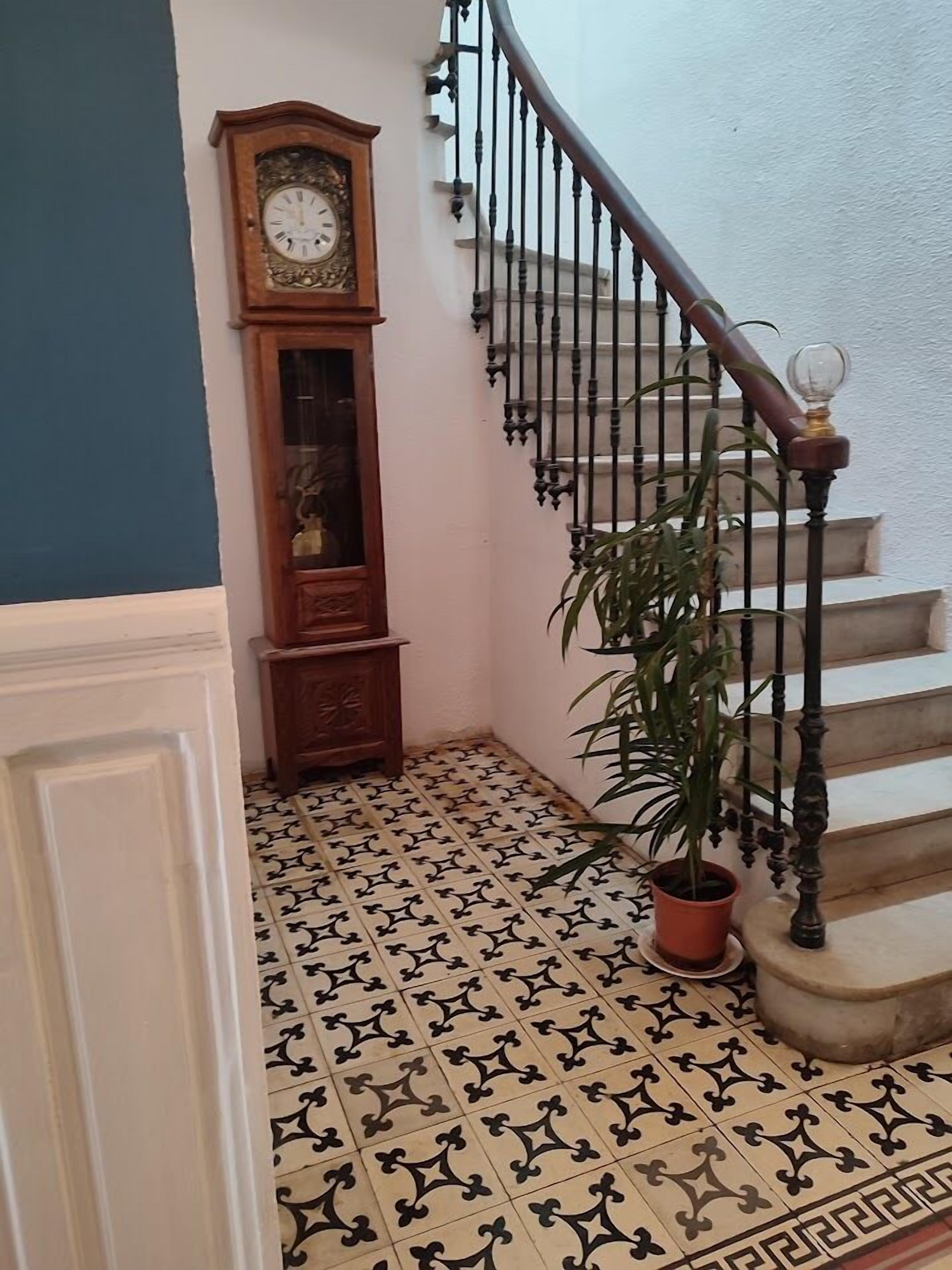 Un escalier orné de balustres et une plante en pot placée à côté.