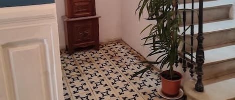 A staircase with ornate balusters and a potted plant beside it.