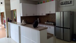 A modern kitchen with white cabinets, a stainless steel refrigerator, and a 'SMILE' sign on the wall. - Villa Martini in heart of Seminyak (Seminyak)