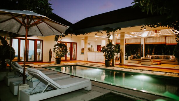 A poolside area with lounge chairs, a covered seating area, and a view of the pool. - Villa Martini in heart of Seminyak (Seminyak)