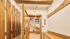 A hallway with wooden doors, a staircase, and a wooden counter.