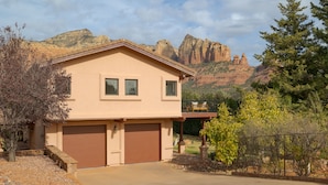 A two-story house with a garage, surrounded by a landscaped driveway and a mountain backdrop. - Red Rocks Views, Walk to Jordan Trailhead, Hot Tub | Sedona Sunrise by AvantStay (Sedona)