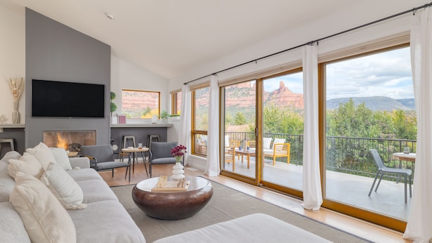 A modern living room with a fireplace, a large flat-screen TV, and a sofa. - Red Rocks Views, Walk to Jordan Trailhead, Hot Tub | Sedona Sunrise by AvantStay (Sedona)