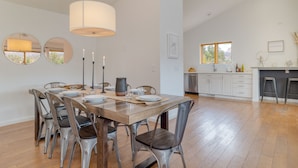 A dining area with a wooden table, metal chairs, and a hanging light fixture. - Red Rocks Views, Walk to Jordan Trailhead, Hot Tub | Sedona Sunrise by AvantStay (Sedona)