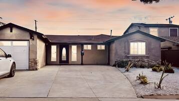 A residential house with a garage, a driveway, and a small garden area.