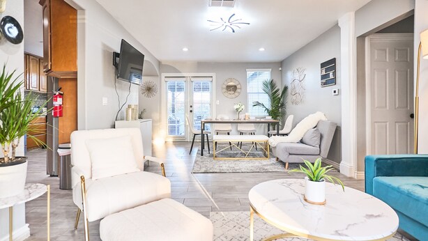 A modern living room with a white sofa, a round coffee table, and a blue sofa. - Modern Retreat w/ Private Spa, Arcade, Playground, Disney, Convention & Beaches (Anaheim)