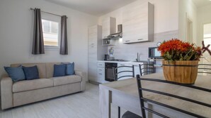 A modern apartment with a living area, kitchenette, and dining space. - Acqua Marina by Interhome (Valledoria)