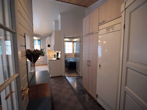 A narrow hallway with a bed in the background, a kitchenette area, and a door leading to another room. - Tunturituuli a by Interhome (Inari)