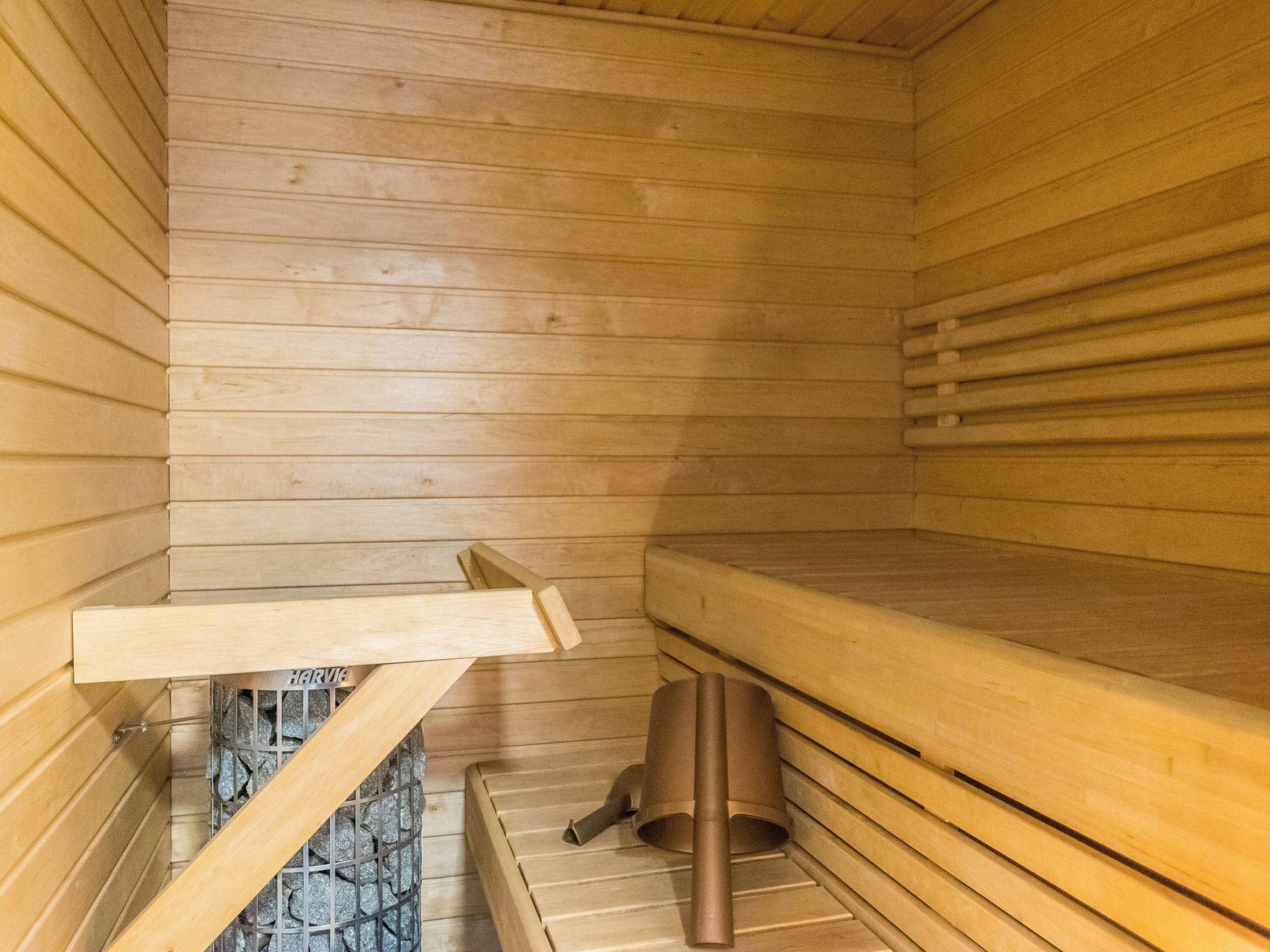 A sauna with wooden benches and a stone floor.