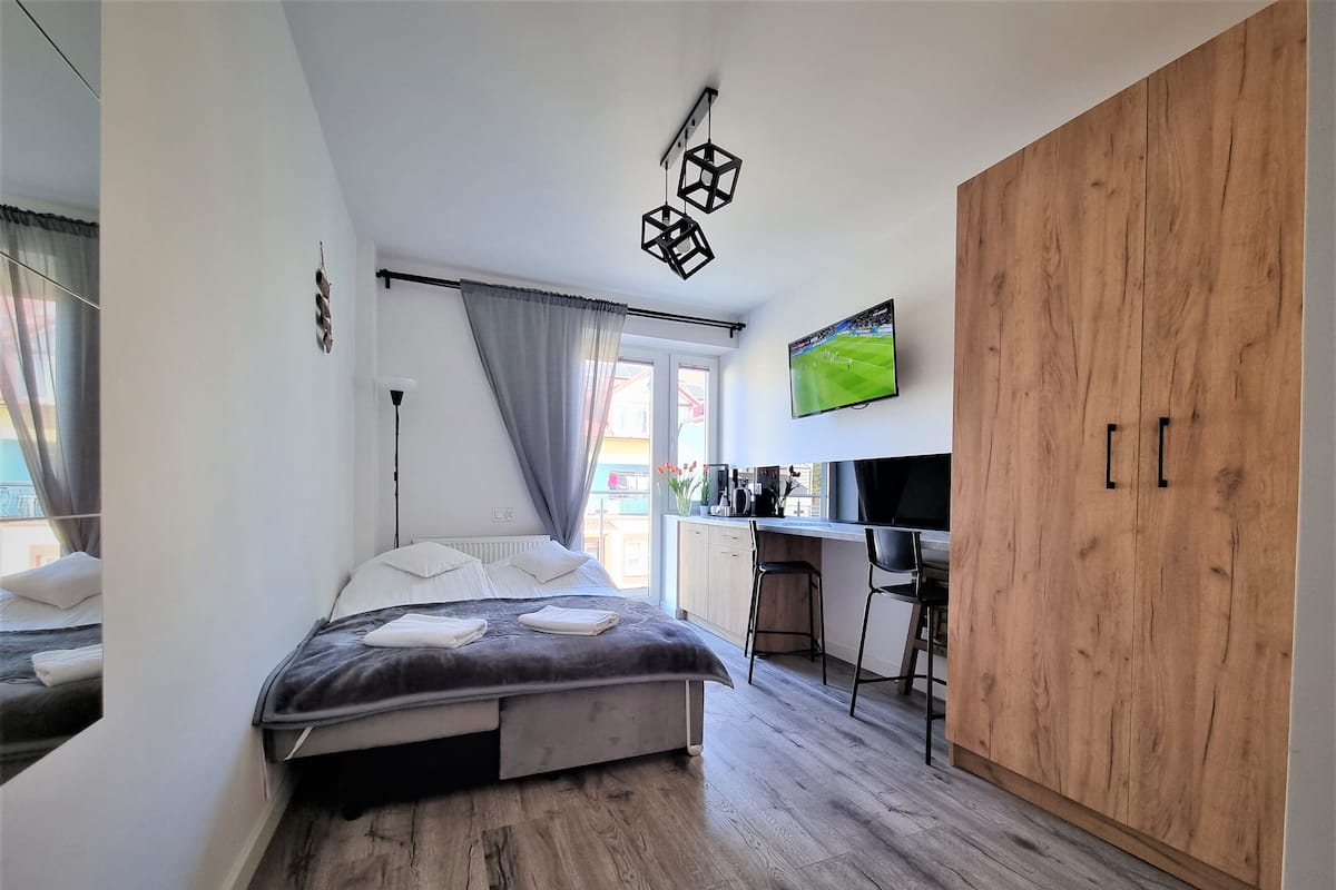 Une chambre à coucher avec un lit, un bureau et une télévision.