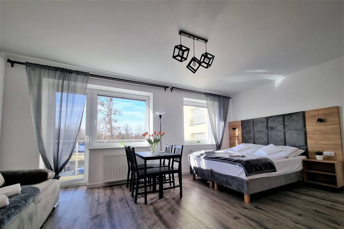 Une chambre moderne avec un lit, une table à manger et une vue sur l’extérieur.