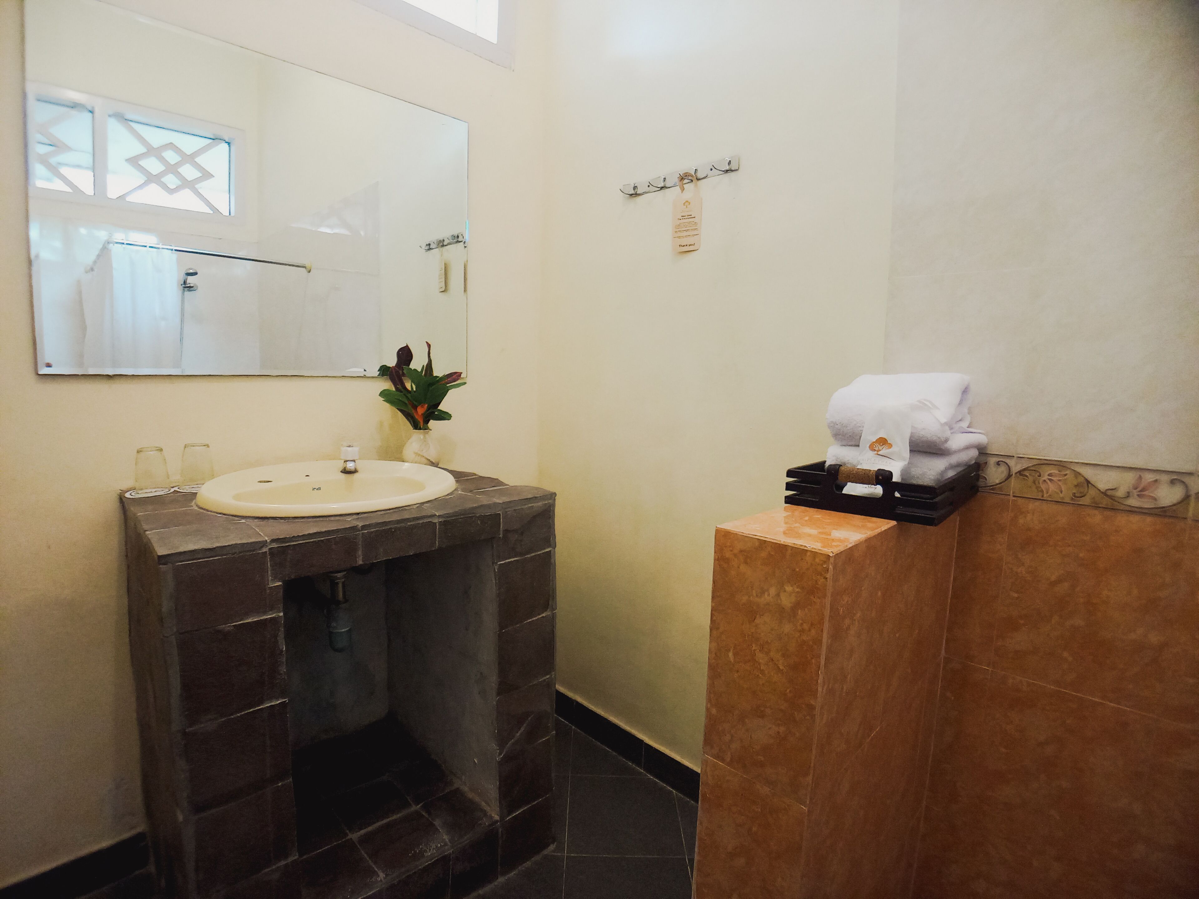 A bathroom with a sink, mirror, and towel rack.