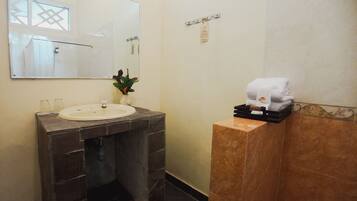 A bathroom with a sink, mirror, and towel rack.
