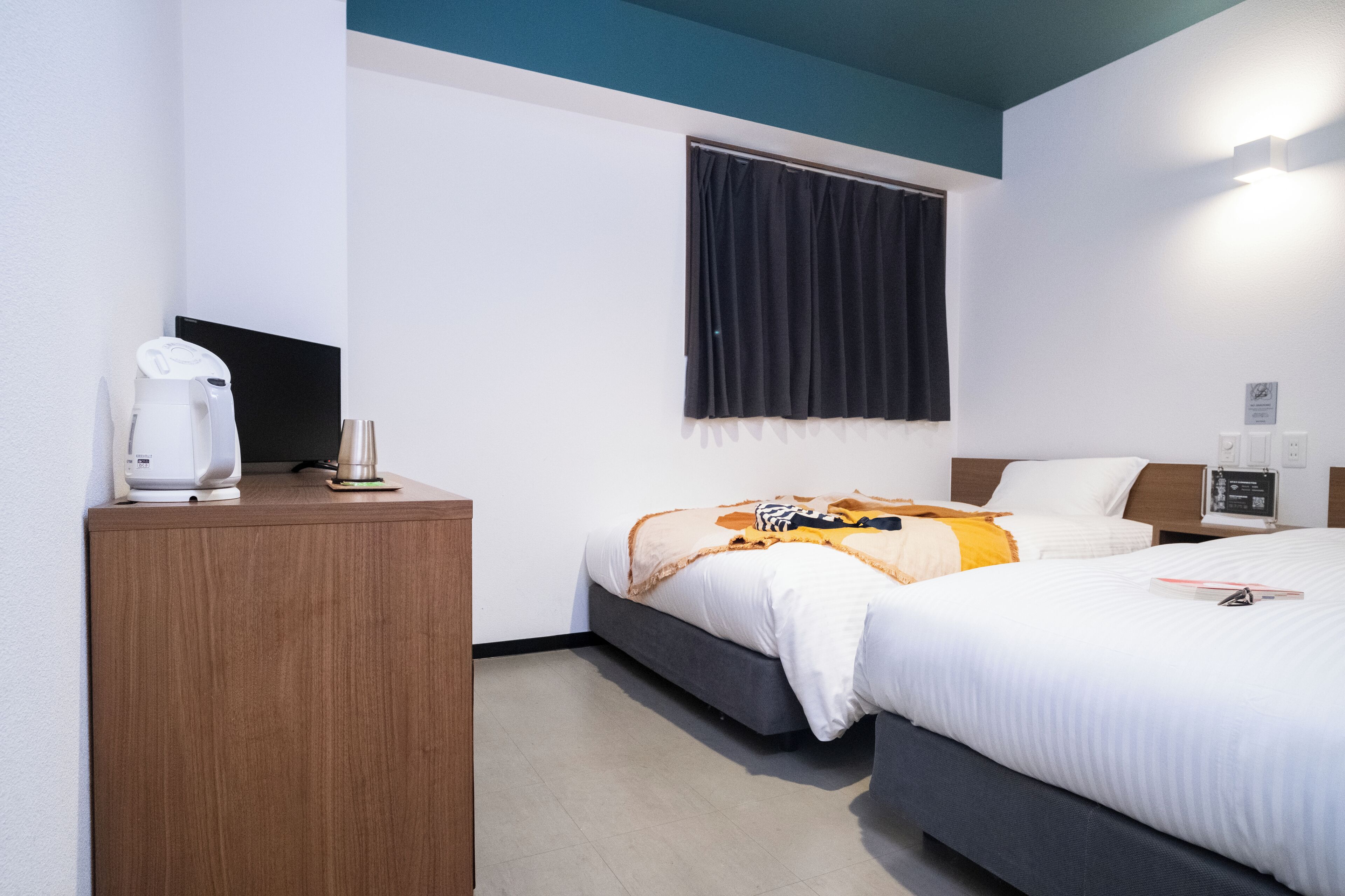 Ein Hotelzimmer mit einem Bett, einem Nachttisch und einer Kaffeemaschine.
