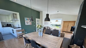 Une cuisine moderne avec un îlot en bois, des chaises noires et une table à manger.
