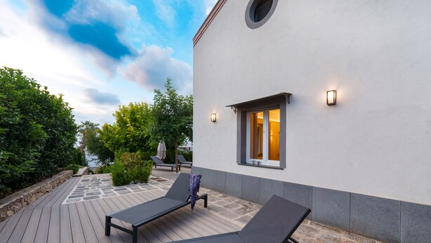 A deck with two lounge chairs, a small table, and a potted plant. - AGAVE B&B (Vico Equense)