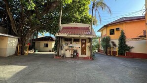 A small, single-story building with a red roof, a small porch, and a signboard. - OYO 1026 Evita Hotel Bacoor (Bacoor City)