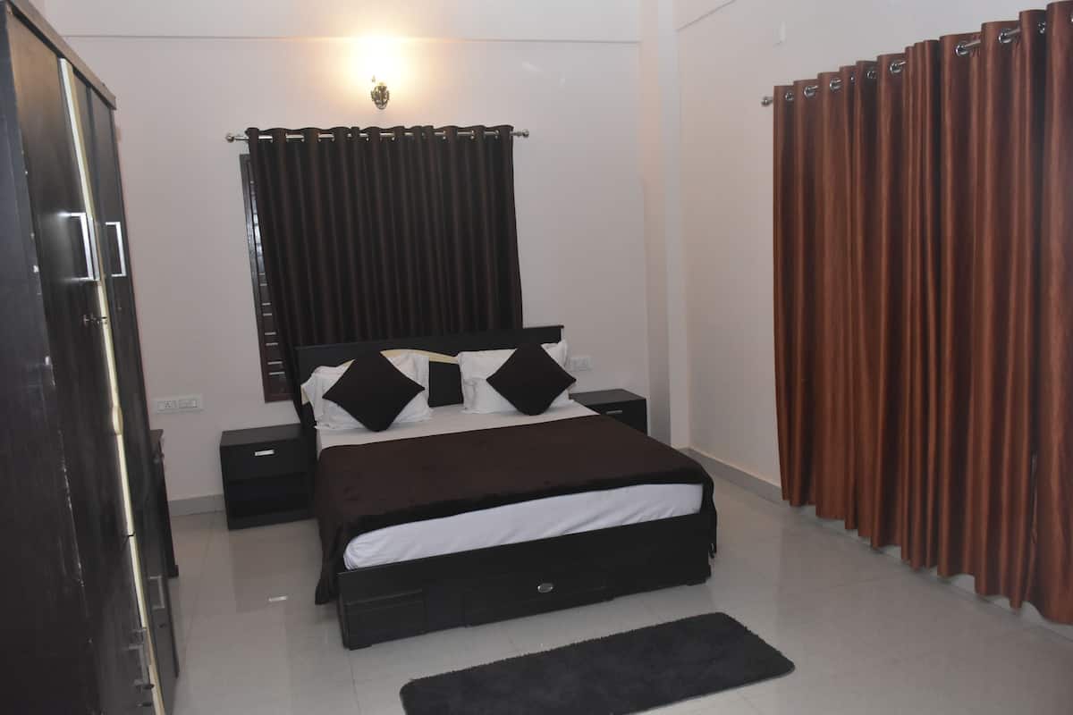 Une chambre à coucher avec un lit, des tables de chevet, une commode et des rideaux.