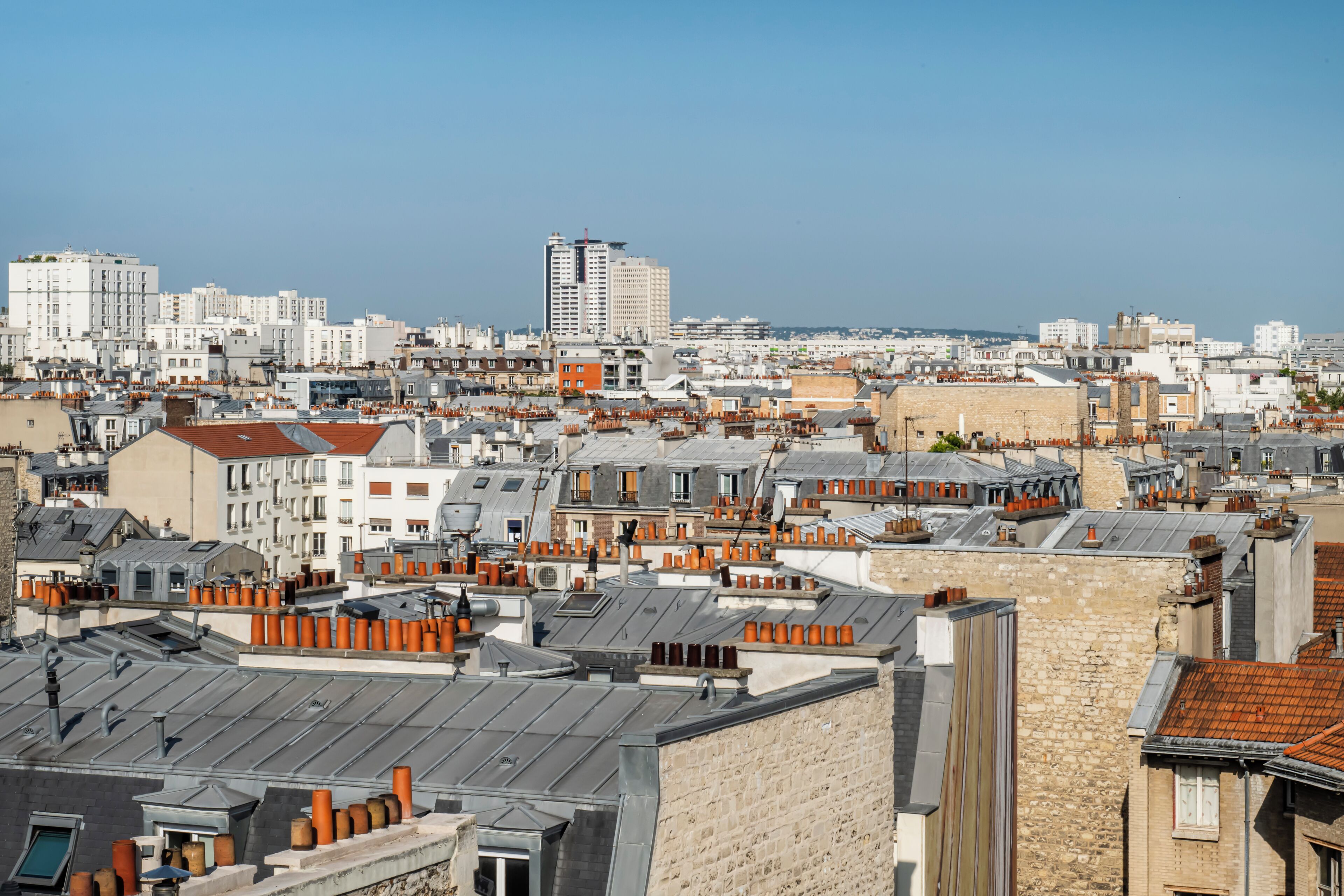 Un área urbana densamente poblada con una variedad de estilos arquitectónicos, que incluyen rascacielos modernos y edificios antiguos de piedra.