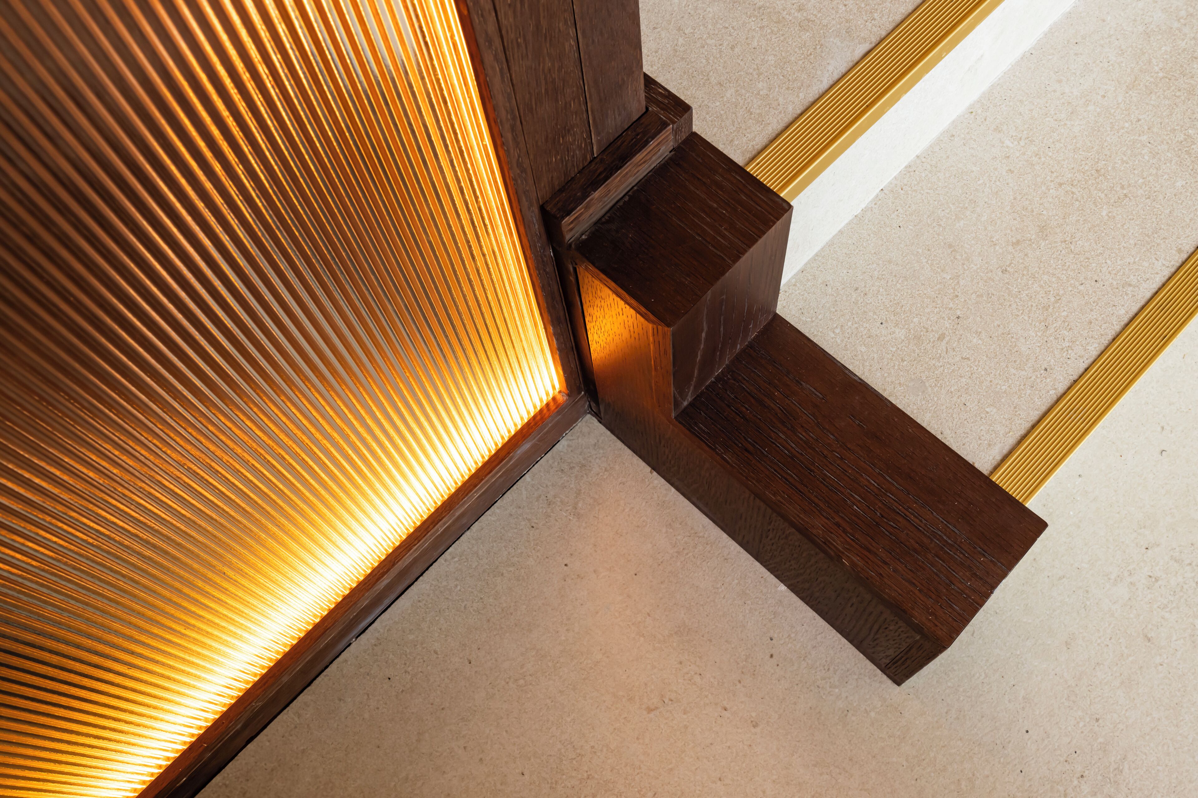 A corner of a room with a wooden floor and a wall with a textured pattern.