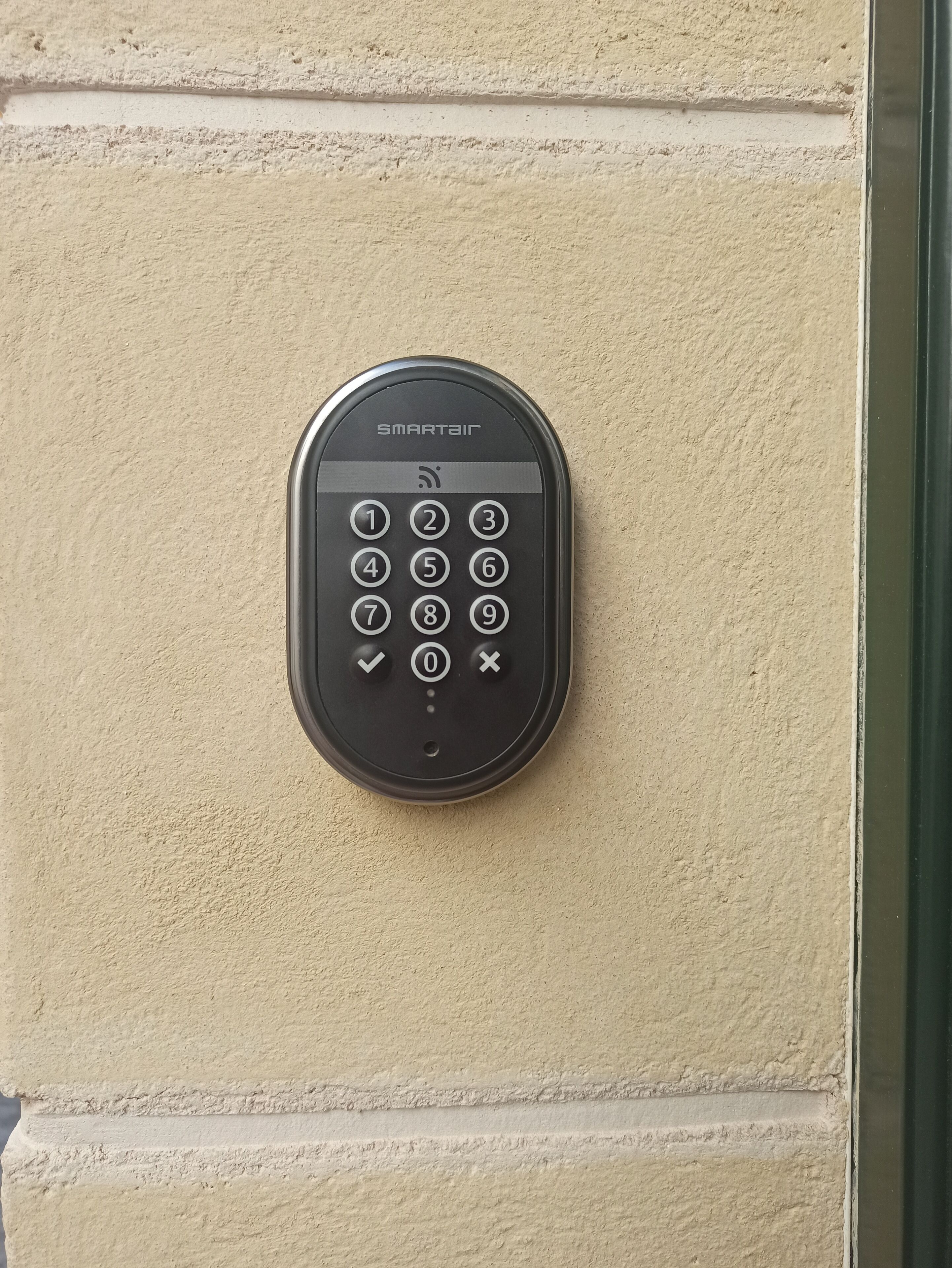 Una cerradura inteligente fijada a la pared, con teclado numérico, marca SMARTAIR.