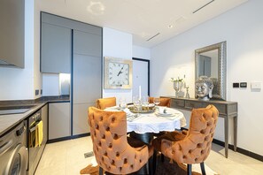 Un espace repas moderne avec une table ronde pour quatre personnes, entourée de chaises à capitonnage.