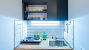 A compact kitchen with a built-in stove, a sink, and a countertop. - HB apartments Tabukashvili (Tbilisi)