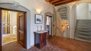 A hallway with wooden beams, stone walls, and a tiled floor. - Villa Chiara - Homelike Villas (Greve in Chianti)