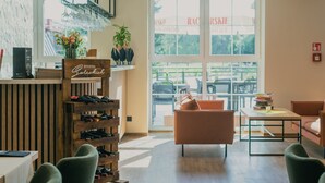 Un interior moderno con un botellero de madera, una zona de estar acogedora y grandes ventanales que ofrecen vistas al exterior.