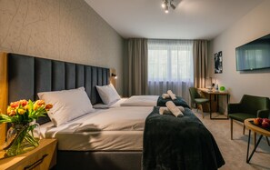 A hotel room with a large bed, a desk, a chair, and a TV. - Country Club Żywiec (Jelesnia)