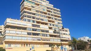 A multi-story building with balconies, a ground-level entrance, and a visible sign for a business named "MAR y LUZ".