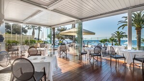 An outdoor dining area with tables and chairs, overlooking the sea. - La Villa Mauresque (Saint-Raphaël)