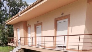 Een gebouw met een plat dak, een overdekte doorgang en een gazon ervoor.