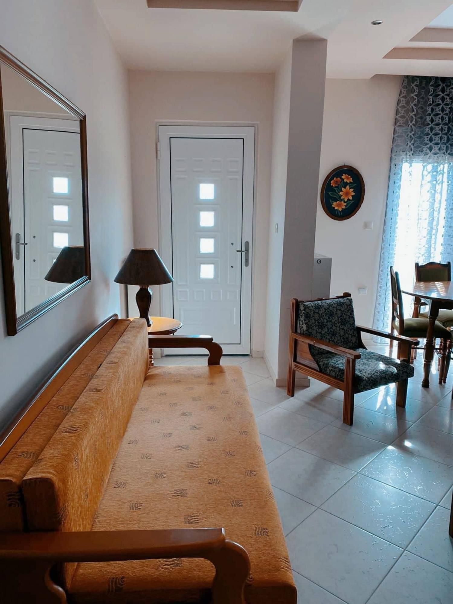 A living room with a sofa, a chair, a table, and a lamp.
