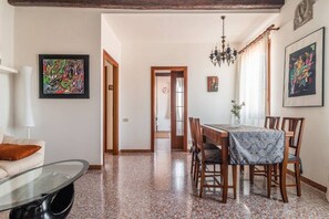 Un comedor con una mesa, sillas y una araña.