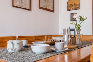 A dining table with tea set, bowls, and a coffee pot.