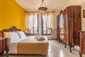 A hotel room with a bed, wooden wardrobe, and a window with curtains. - Colombina House close to @S.Lucia Train Station (Venezia)
