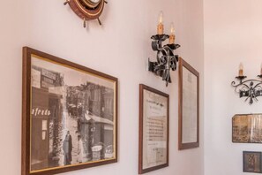 Des photographies historiques encadrées, une horloge murale et des appliques murales décoratives.