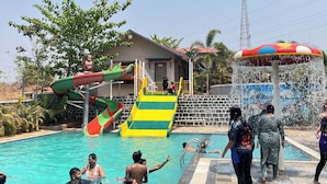 A swimming pool with multiple slides and a water fountain.