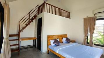 A bedroom with a wooden bed, a staircase, and a window with curtains.
