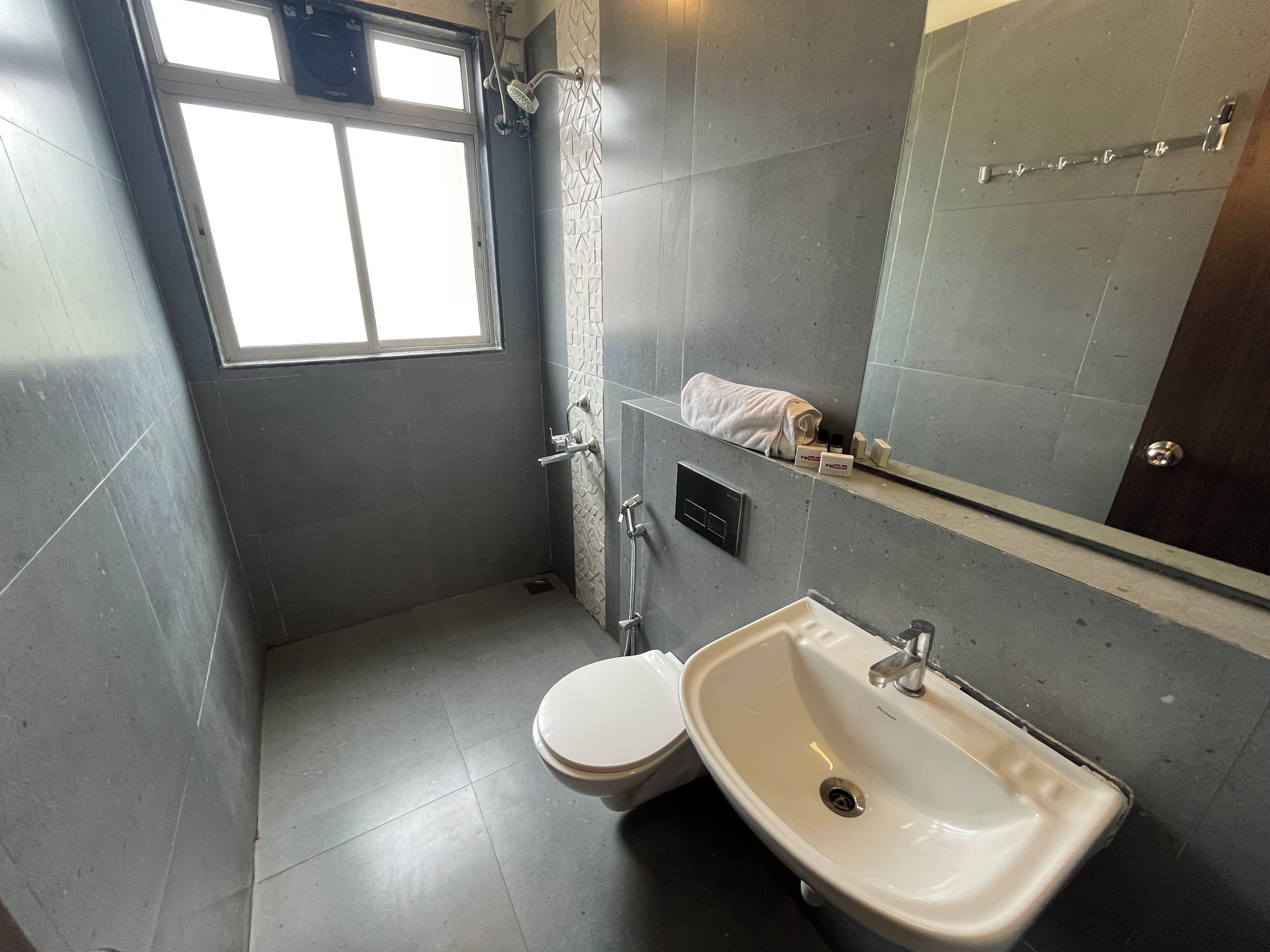 Un baño pequeño con inodoro, lavamanos y zona de ducha.