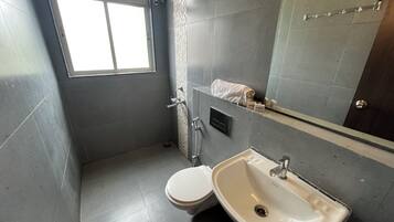 Un baño pequeño con inodoro, lavamanos y zona de ducha.