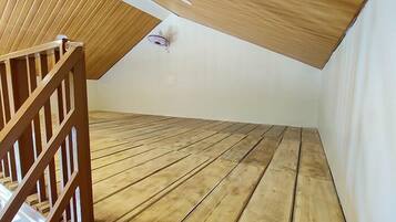 A room with a sloped ceiling and wooden flooring.