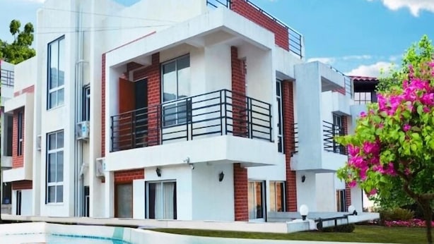 A modern two-story building with a swimming pool in front.
