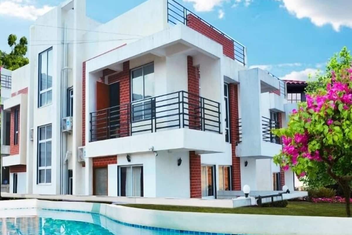 Un edificio moderno de dos pisos con una piscina delantera.