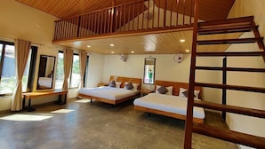 A room with two beds, a wooden ceiling, and a balcony.