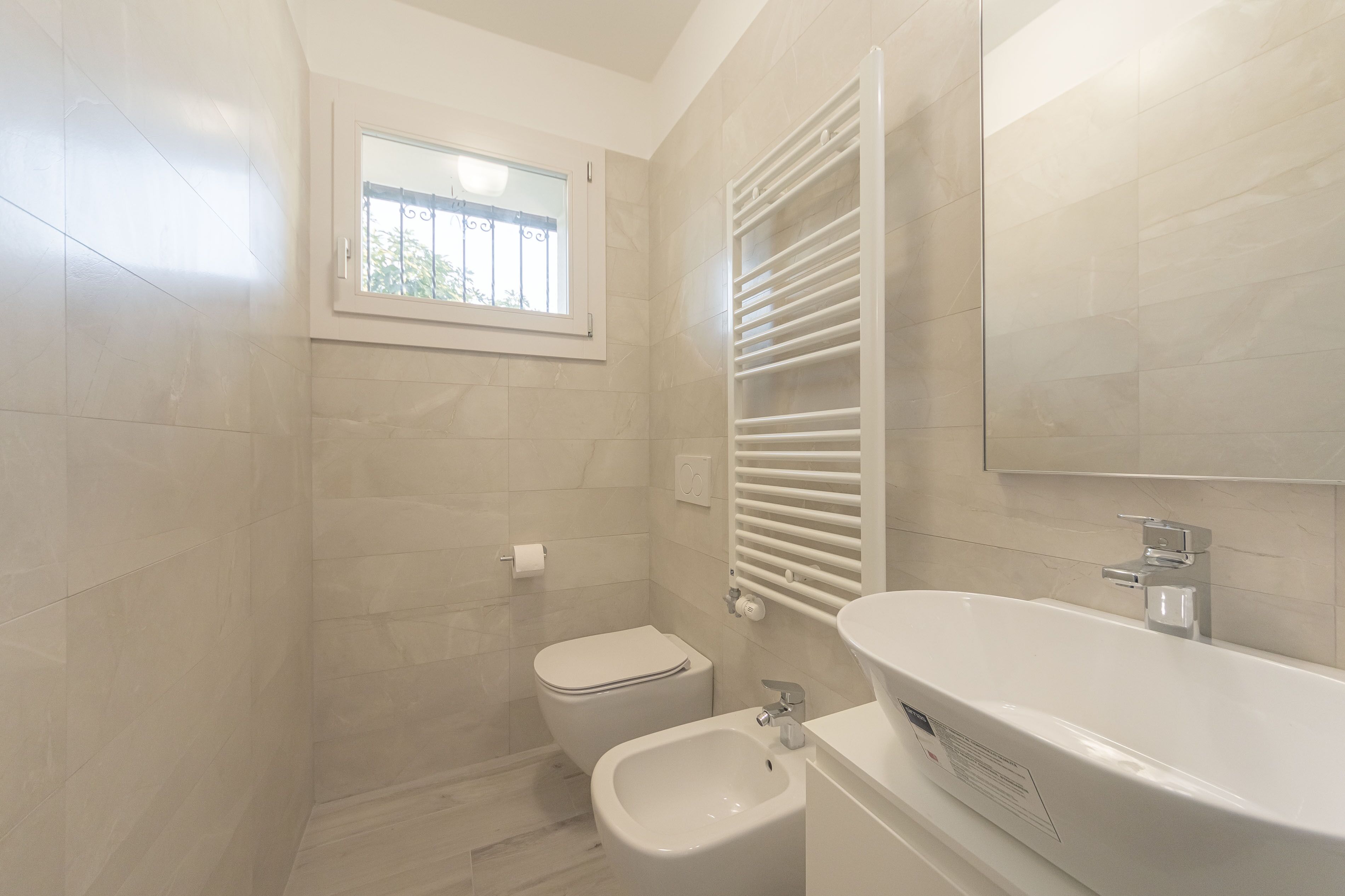 A modern bathroom with a toilet, bidet, and bathtub.