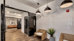 A modern lobby with a wooden floor, wicker furniture, and pendant lighting. - New Construction Loft Style Spacious Lux Apt 201 (Atlanta)