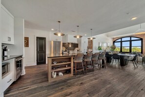 A modern kitchen with a central island, bar stools, and pendant lighting. - Benz View Penthouse w Rooftop, Secure Parking (Atlanta)