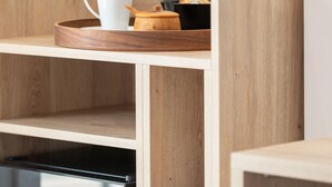 A wooden shelf with a white mug, a wooden tray, and a small container. - Calives Premium Stay (Polygyros)
